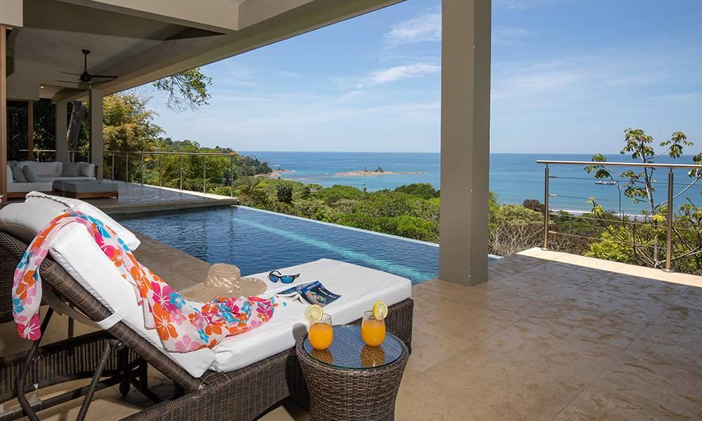 La piscina de agua salada de infinidad y la terraza cubierta ofrecen vistas directas y expansivas del Océano Pacífico y exuberante costa, bañada con luz natural.